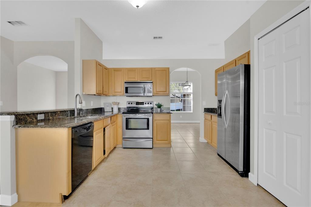 357 Kirkhill Street Ocoee, FL 34761 - Photo 7 of 36 a kitchen with stainless steel appliances granite countertop a refrigerator sink and stove