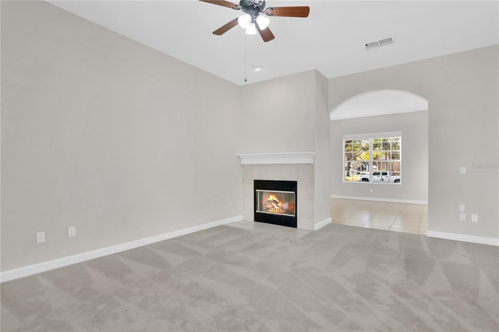 357 Kirkhill Street Ocoee, FL 34761 - Photo 10 of 36 an empty room with windows and a fireplace