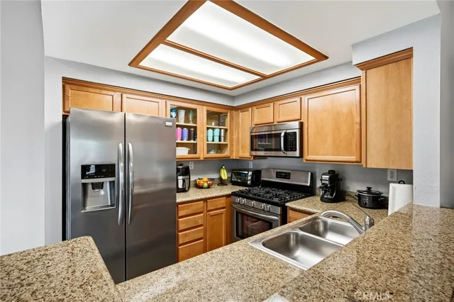 a kitchen with granite countertop a refrigerator stove and sink