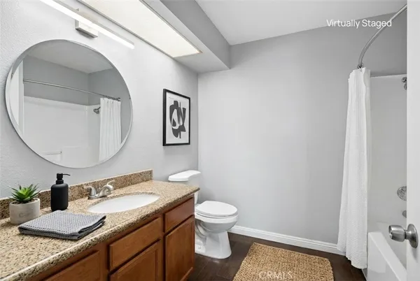 a bathroom with a granite countertop sink toilet and mirror