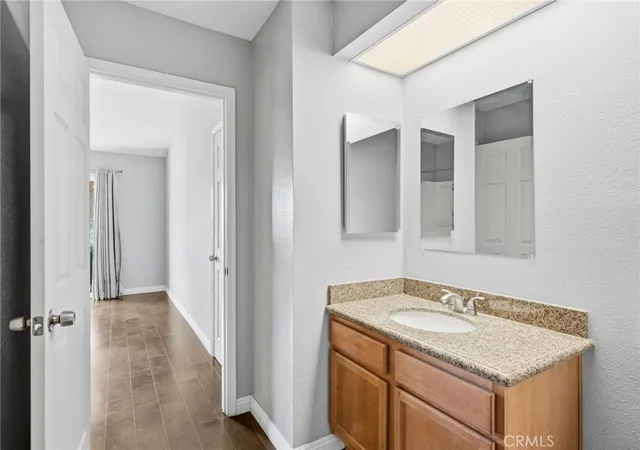 a bathroom with a granite countertop sink and a mirror
