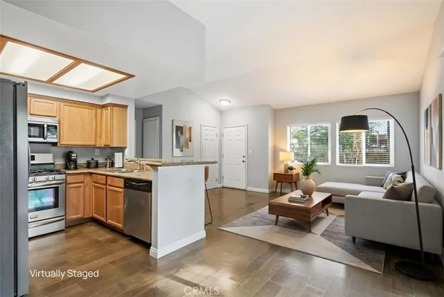 a kitchen with stainless steel appliances granite countertop a sink and a refrigerator