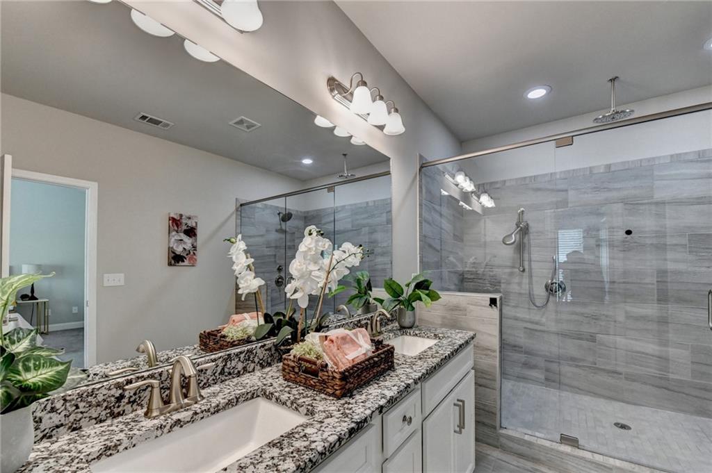 4158 Butler Drive Atlanta, GA 30341 - Photo 45 of 65 a bathroom with a granite countertop sink a shower and a mirror