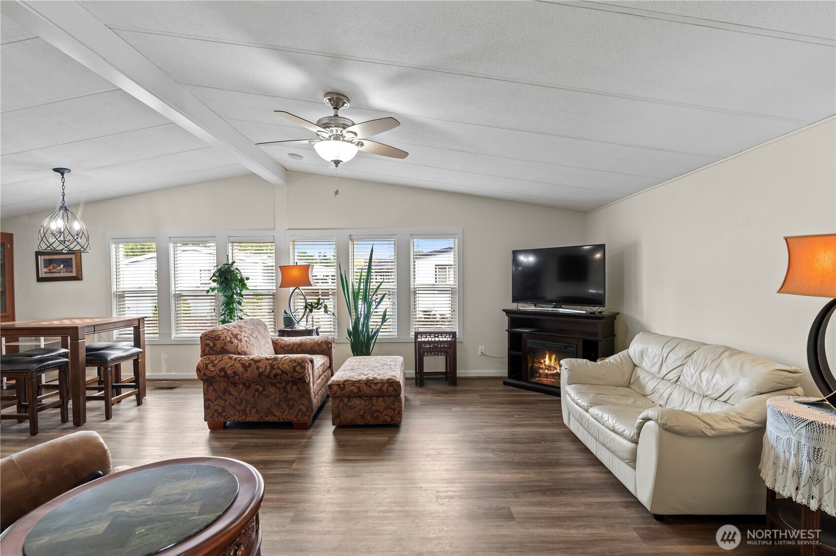 a living room with furniture a flat screen tv and a large window