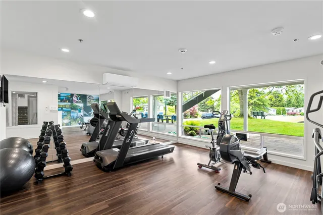 a view of a room with gym equipment and large windows