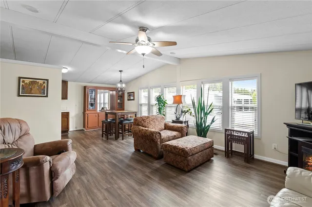 a living room with furniture kitchen view and a large window