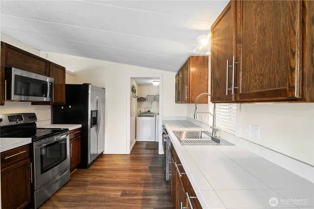 a kitchen with a sink a stove top oven and refrigerator