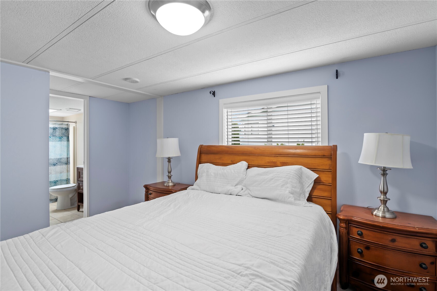 1427 100th Street Southwest, Unit 145 Everett, WA 98204 - Photo 26 of 36 a bedroom with a bed and a lamp