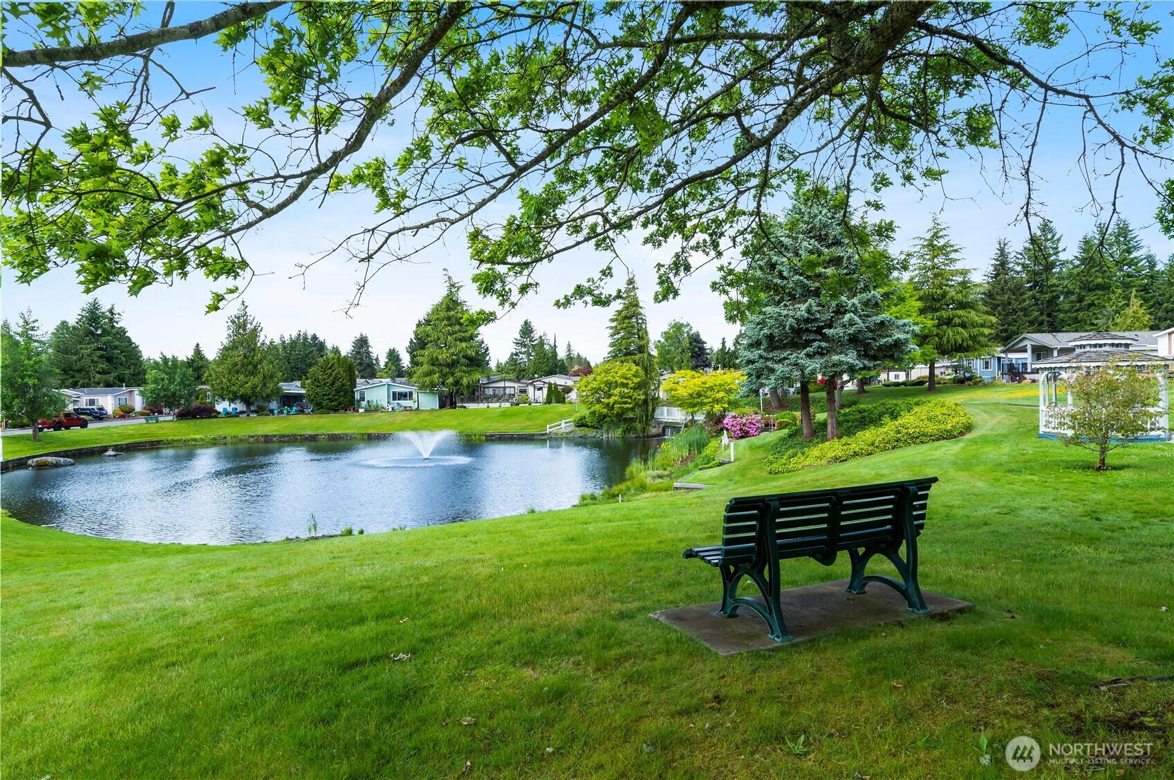 1427 100th Street Southwest, Unit 145 Everett, WA 98204 - Photo 5 of 36 a view of a lake with a bench and trees