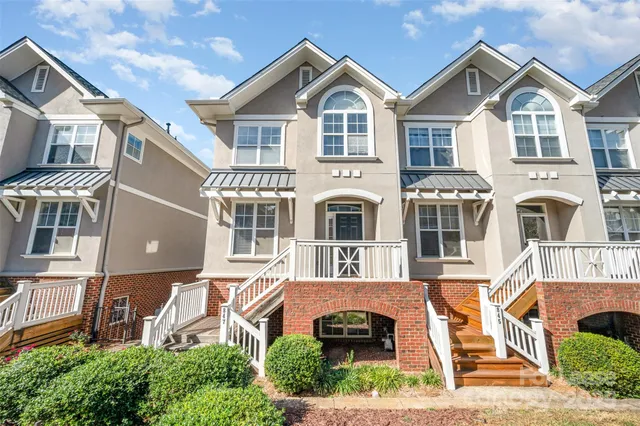 a front view of a residential houses with yard and parking space
