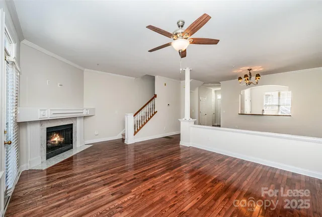 an empty room with wooden floor a fireplace and windows