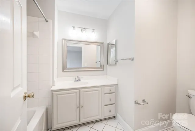 a bathroom with a sink toilet vanity and tub