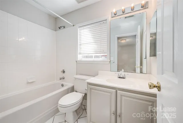 a bathroom with a sink toilet vanity and bathtub