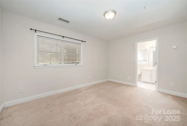 an empty room with white cabinet and windows
