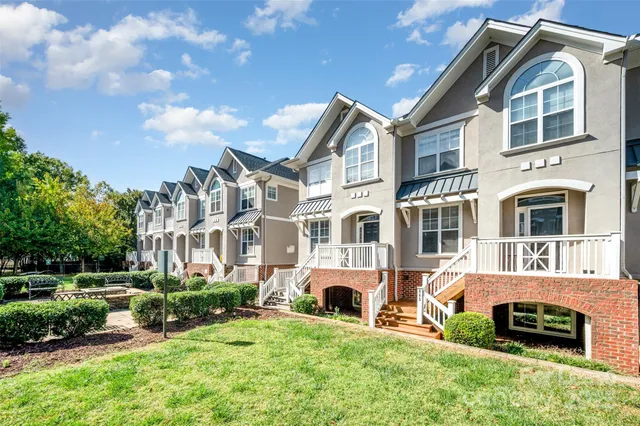 a front view of residential houses with yard and green space