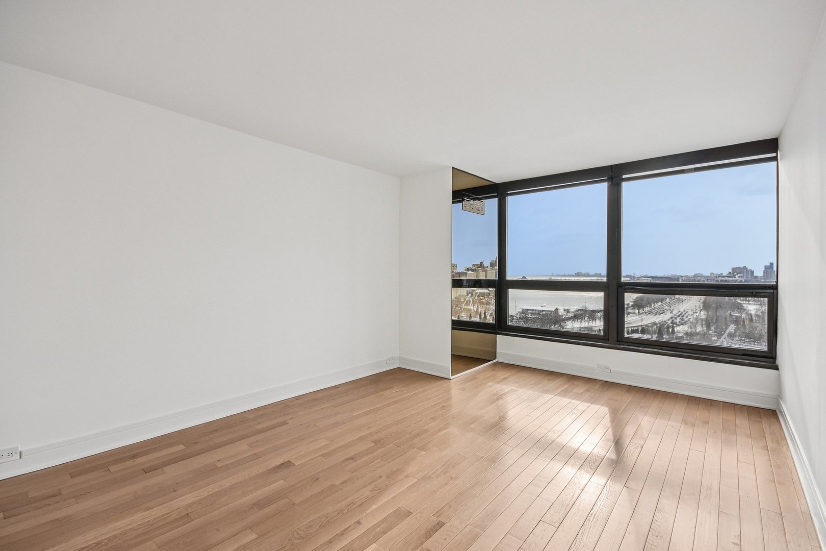 360 East Randolph Street, Unit 1102 Chicago, IL 60601 - Photo 12 of 27 wooden floor in an empty room with a window