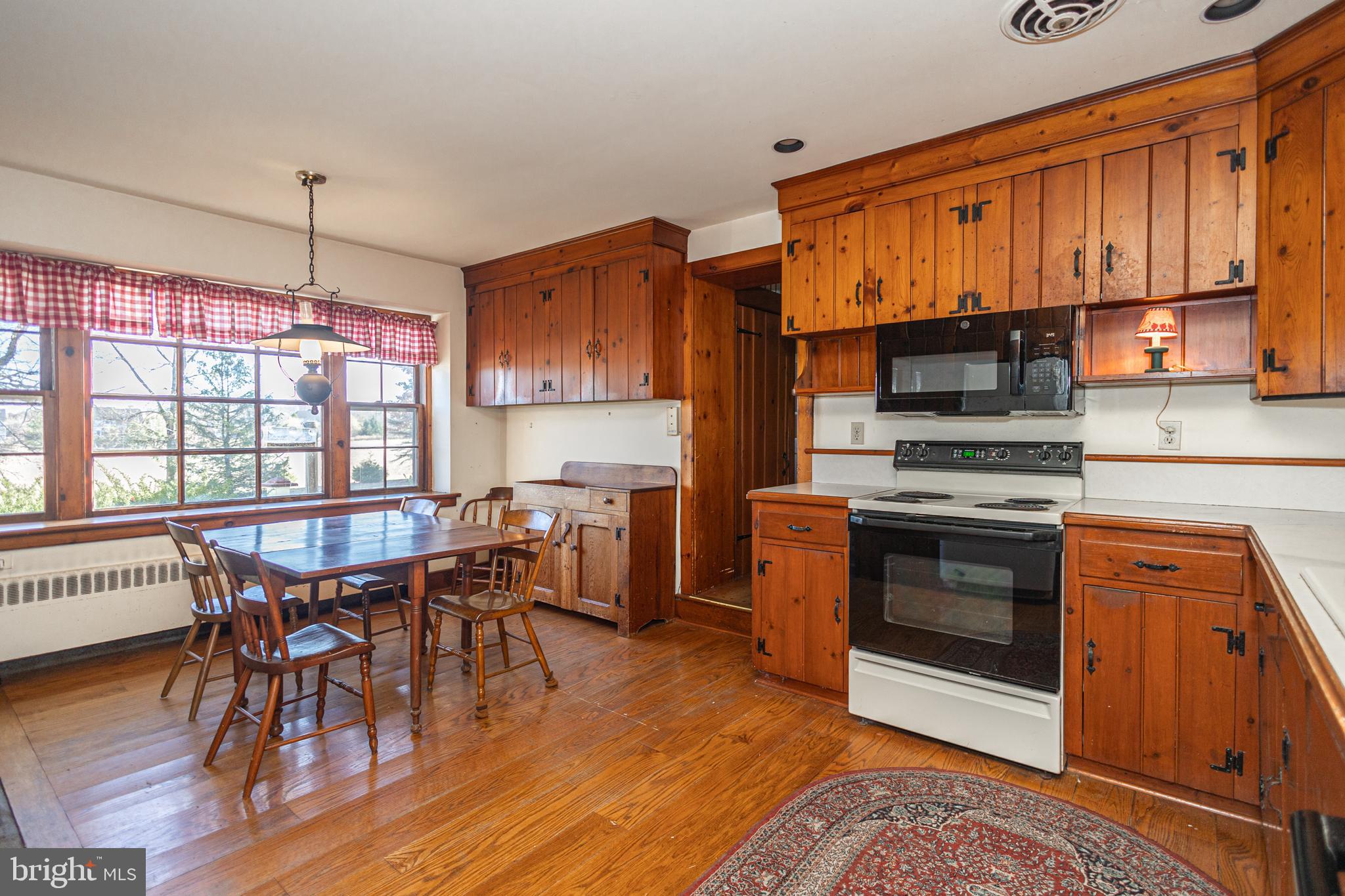 2209 Swamp Road Furlong, PA 18925 - Photo 13 of 59 a kitchen with stainless steel appliances a stove a sink dishwasher a dining table and chairs with wooden floor
