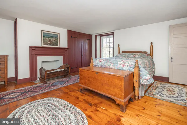 a bedroom with a bed a dresser and a window