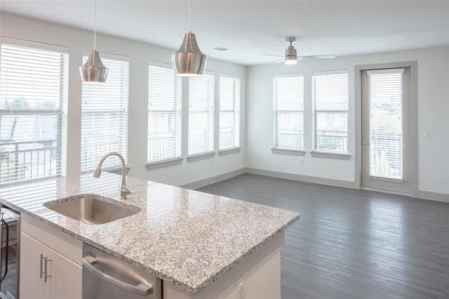 a kitchen with granite countertop a sink a stove and cabinets