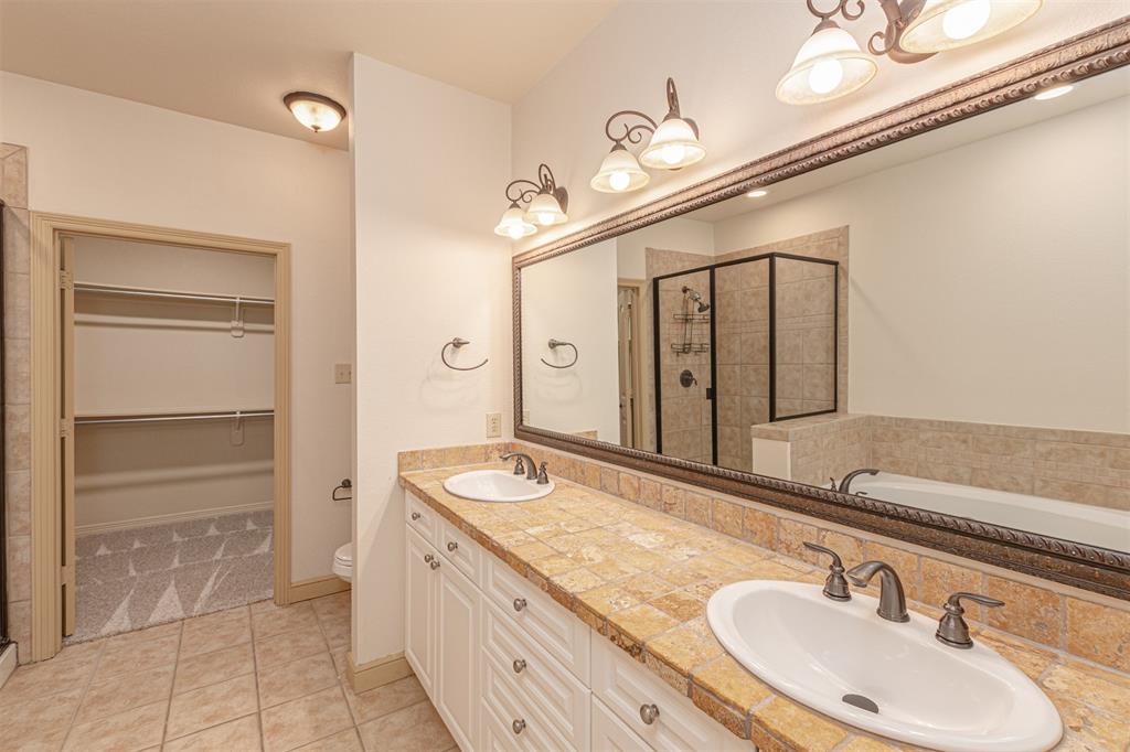 1871 Signal Ridge Place Rockwall, TX 75032 - Photo 17 of 26 a bathroom with a granite countertop sink a mirror and a shower