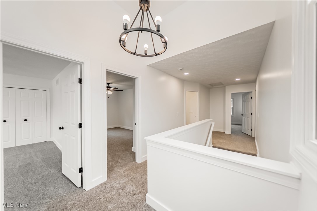 7488 Greenwich Road Seville, OH 44273 - Photo 11 of 37 Hall with light colored carpet, a chandelier, recessed lighting, and an upstairs landing