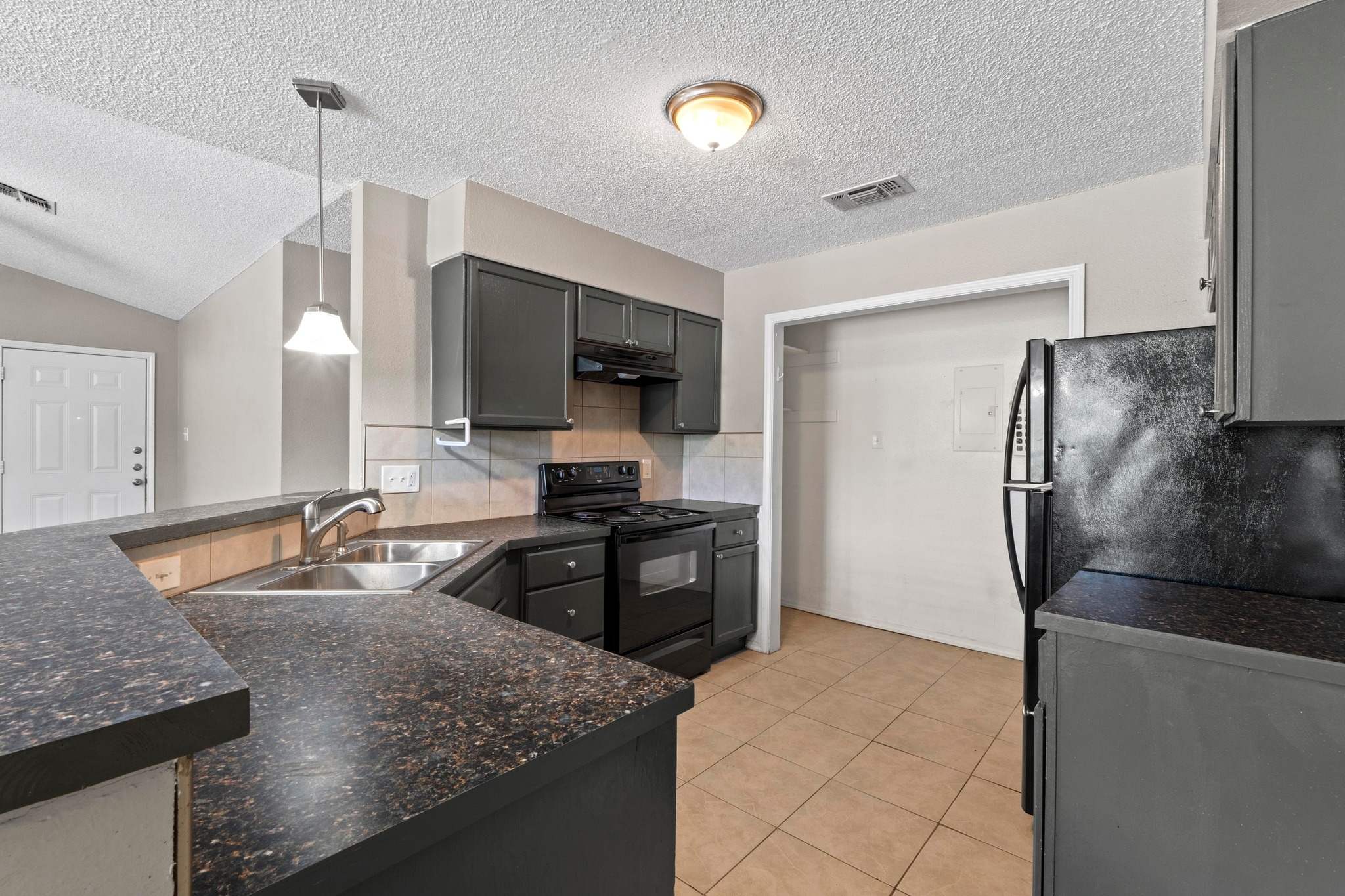4208 Duval Road, Unit C Austin, TX 78759 - Photo 9 of 28 Kitchen with black / electric stove, decorative backsplash, a peninsula, decorative light fixtures, and a textured ceiling