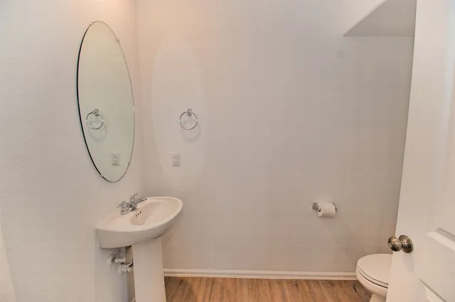 a bathroom with a sink a toilet and a mirror