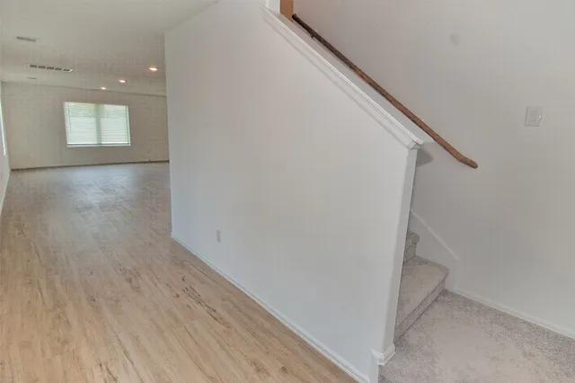 a view of hallway with stairs and wooden floor