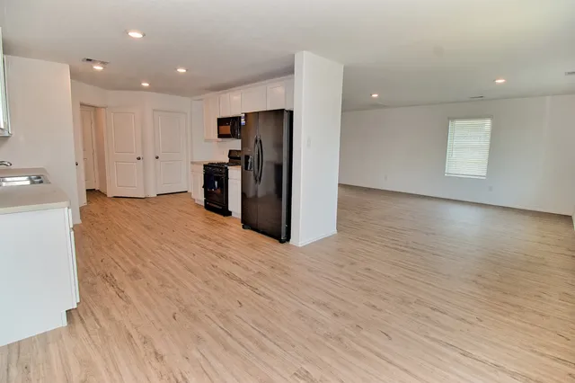 a view of a kitchen with a refrigerator and a microwave