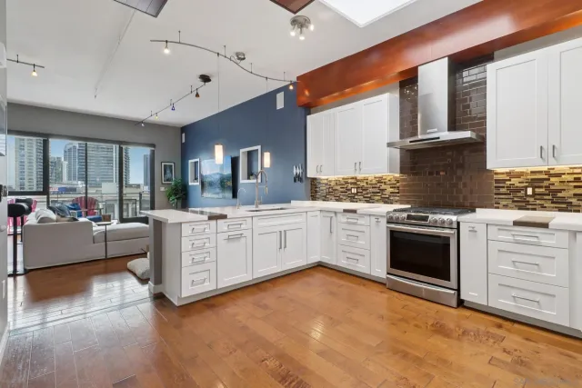 a kitchen with stainless steel appliances kitchen island granite countertop a stove and a sink