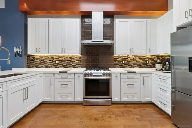a kitchen with stainless steel appliances granite countertop a stove a sink and a refrigerator