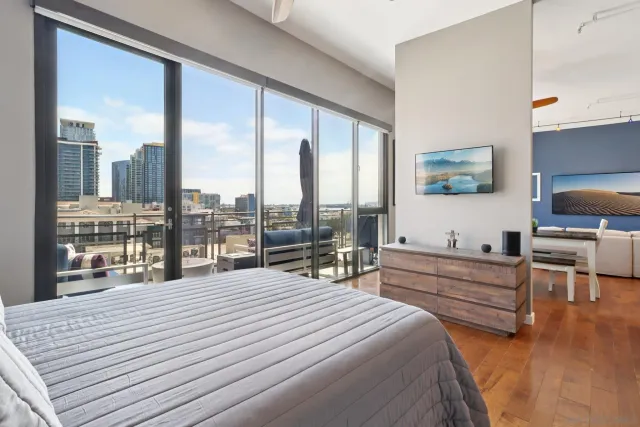 a bedroom with a bed and large windows