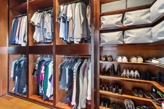 a view of walk in closet with clothes and shoes