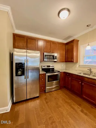 a kitchen with stainless steel appliances granite countertop a stove a sink and a refrigerator
