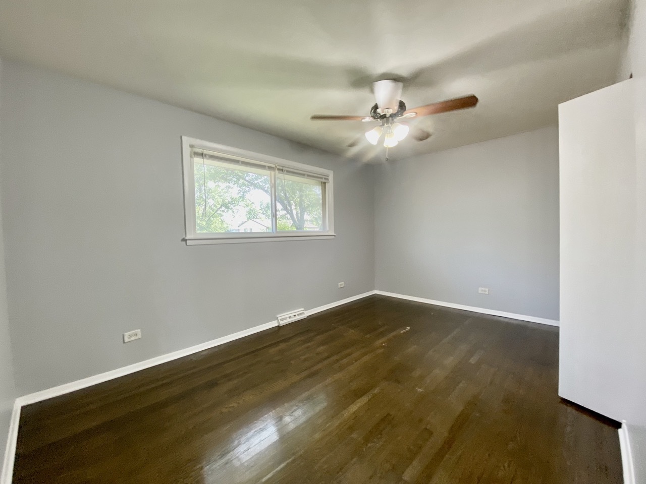 3324 Laurel Lane Hazel Crest, IL 60429 - Photo 9 of 26 an empty room with wooden floor fan and windows
