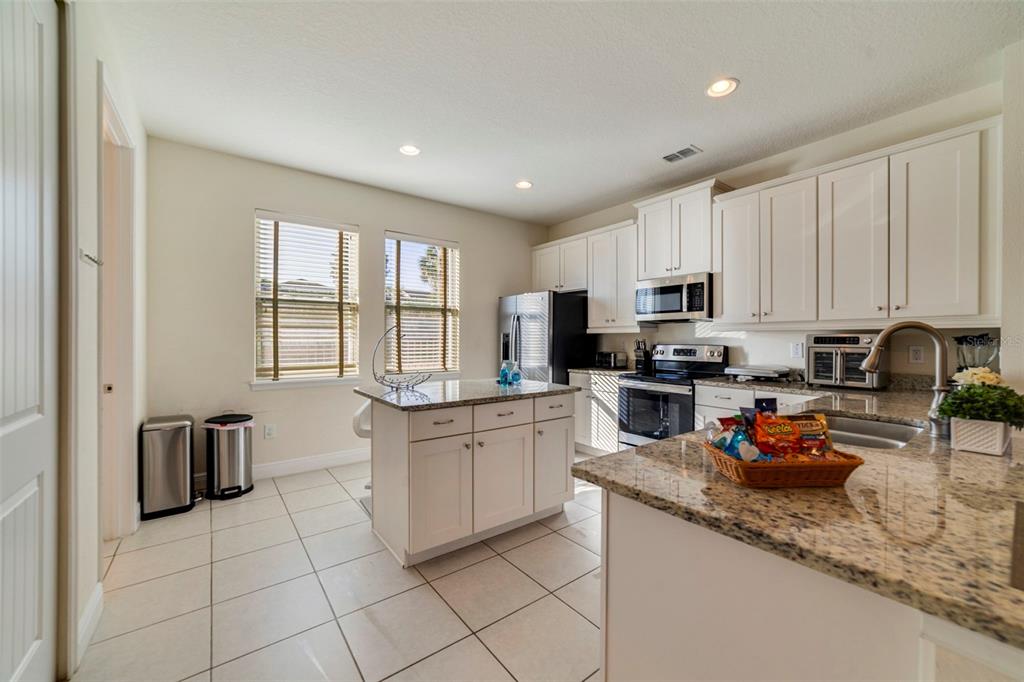 180 Minton Loop Kissimmee, FL 34747 - Photo 12 of 49 a kitchen with stainless steel appliances granite countertop a stove sink microwave and cabinets