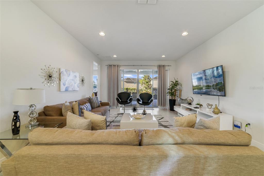 180 Minton Loop Kissimmee, FL 34747 - Photo 15 of 49 a living room with furniture and a large mirror next to a window