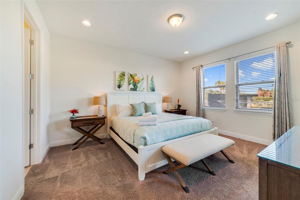 180 Minton Loop Kissimmee, FL 34747 - Photo 21 of 49 a bedroom with a bed a table and painting