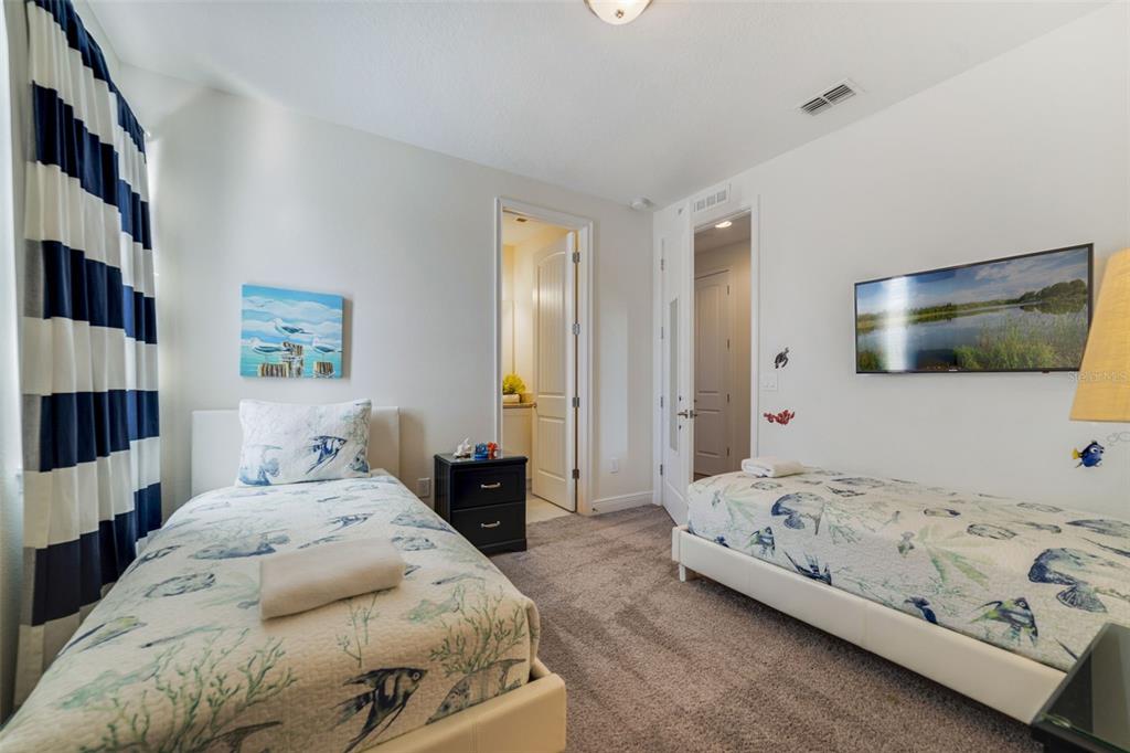 180 Minton Loop Kissimmee, FL 34747 - Photo 31 of 49 a bedroom with a bed and a flat screen tv