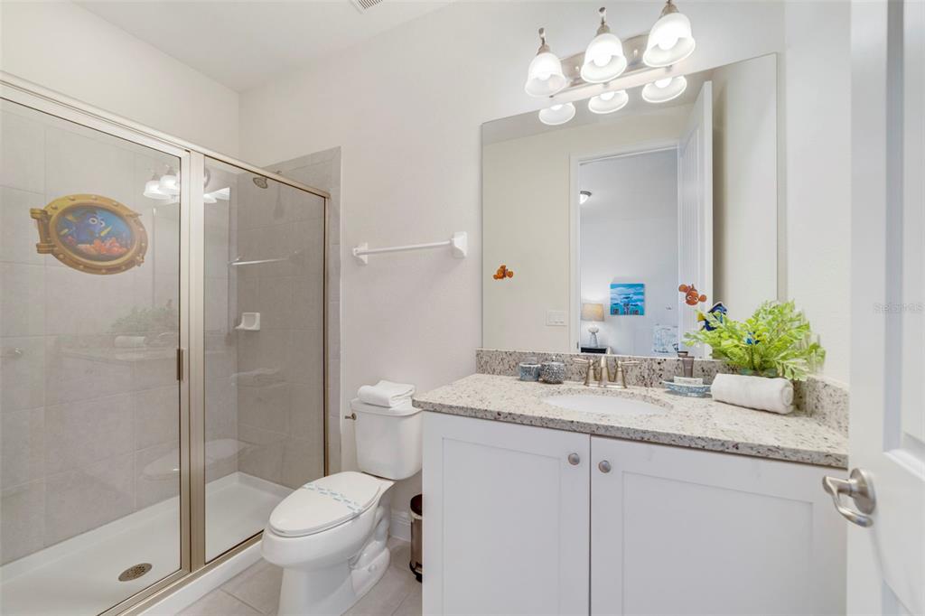 180 Minton Loop Kissimmee, FL 34747 - Photo 32 of 49 a bathroom with a granite countertop sink a toilet and a mirror
