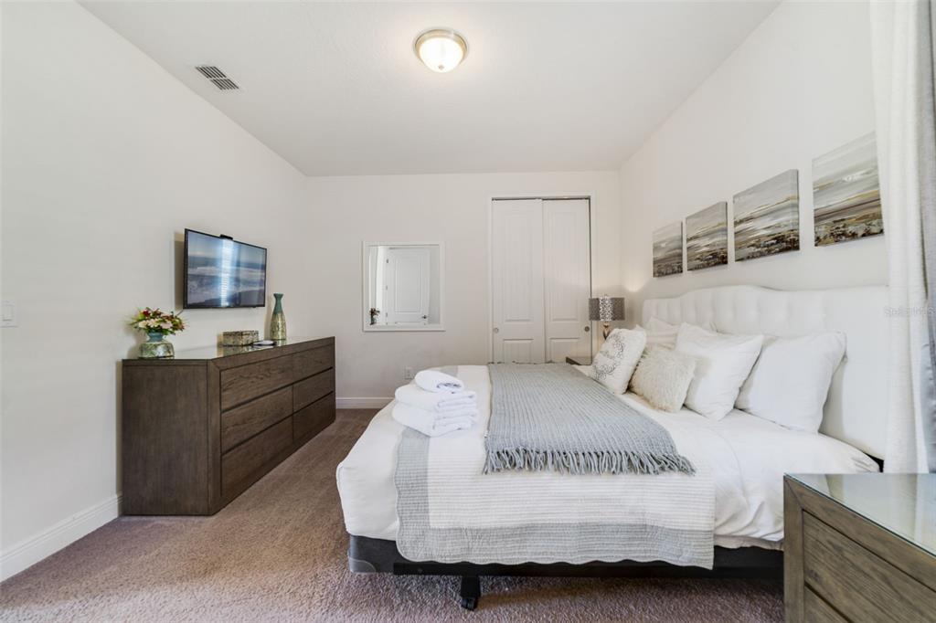 180 Minton Loop Kissimmee, FL 34747 - Photo 35 of 49 a spacious bedroom with a bed and a flat screen tv