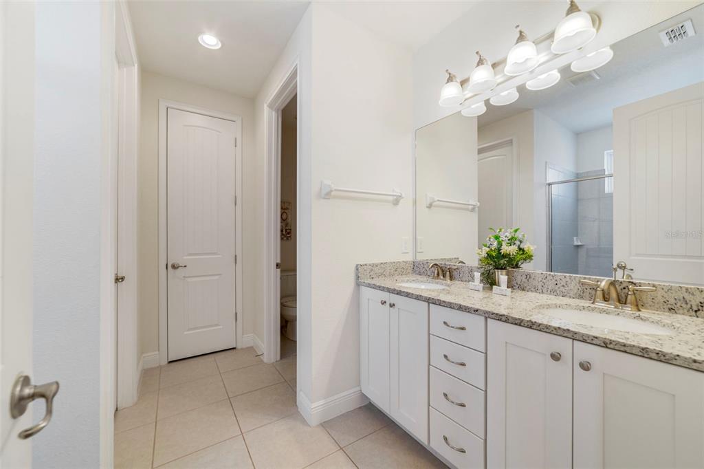180 Minton Loop Kissimmee, FL 34747 - Photo 40 of 49 a spacious bathroom with a granite countertop double vanity and a mirror