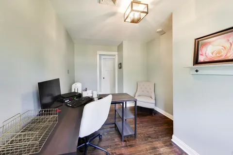a view of a workspace with furniture and wooden floor