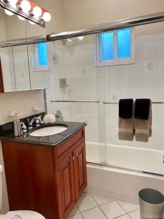 a bathroom with a granite countertop sink a toilet and bathtub
