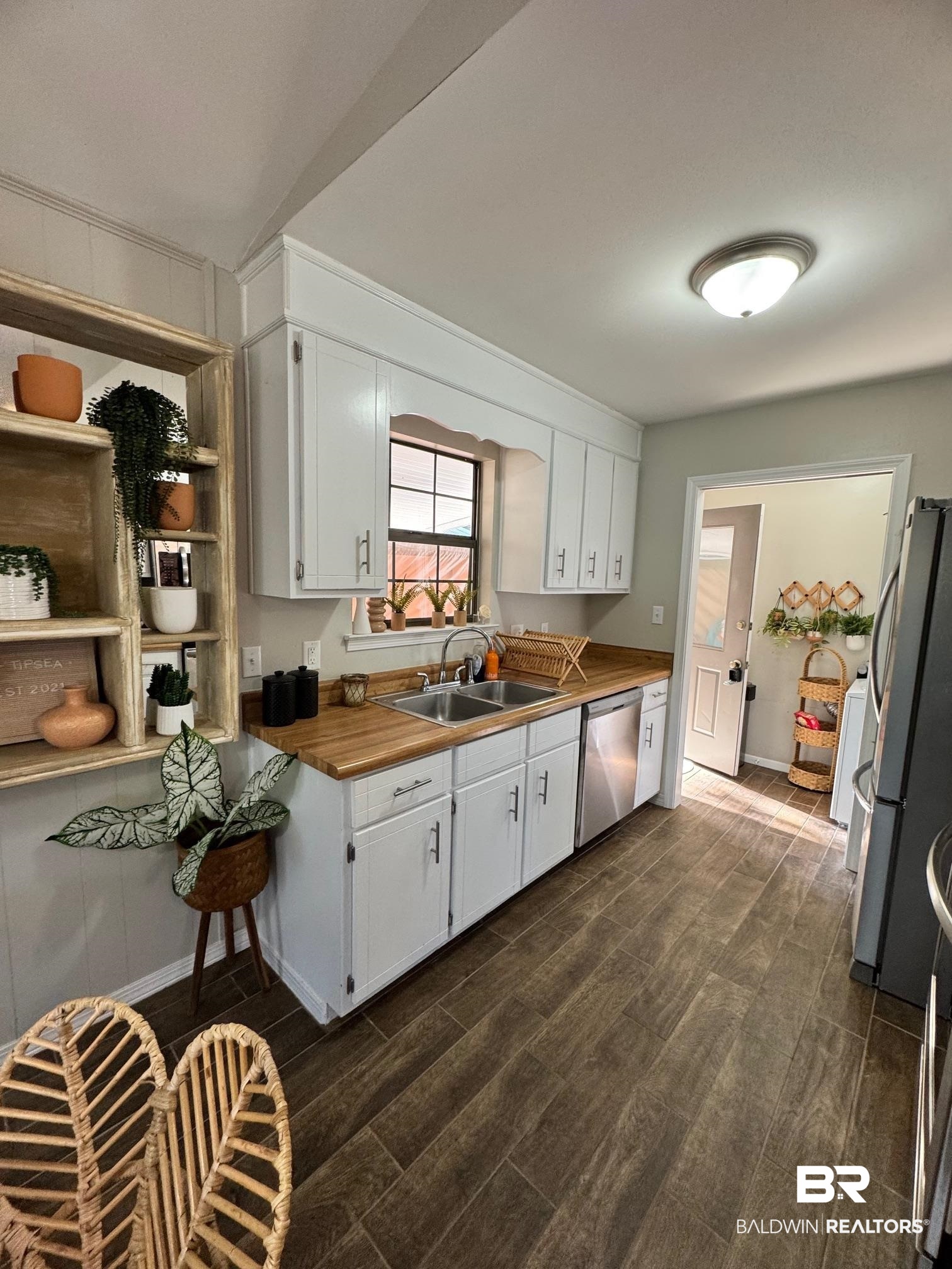 1434 Ridgewood Drive Lillian, AL 36549 - Photo 9 of 45 Kitchen featuring stainless steel appliances, white cabinetry, butcher block counters, and sink