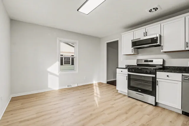 a kitchen with stainless steel appliances a stove a microwave and sink