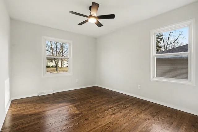 a view of empty room with wooden floor