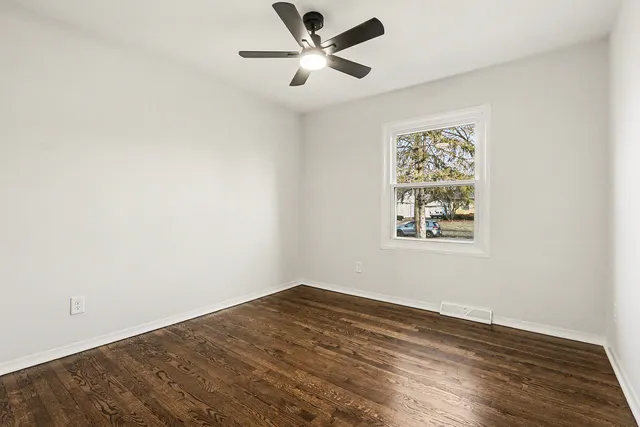 a view of a big room with wooden floor and a ceiling fan