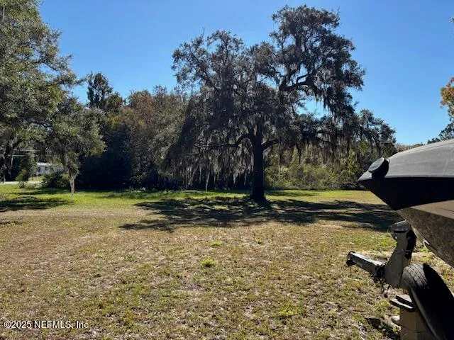 a view of a yard with wooden fence