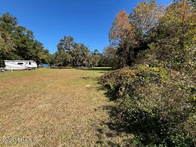 a view of a backyard with wooden fence